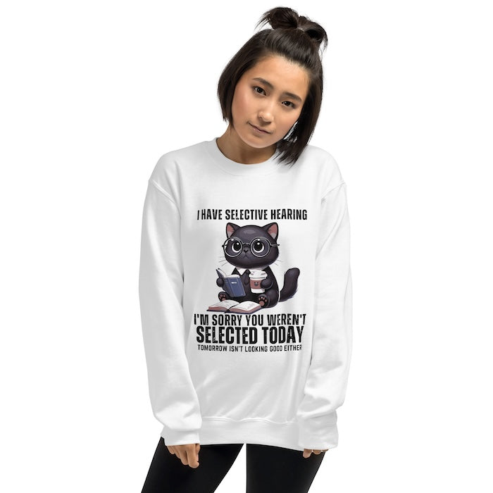 Woman wearing white unisex sweatshirt with cute cat print and fun selective hearing slogan.